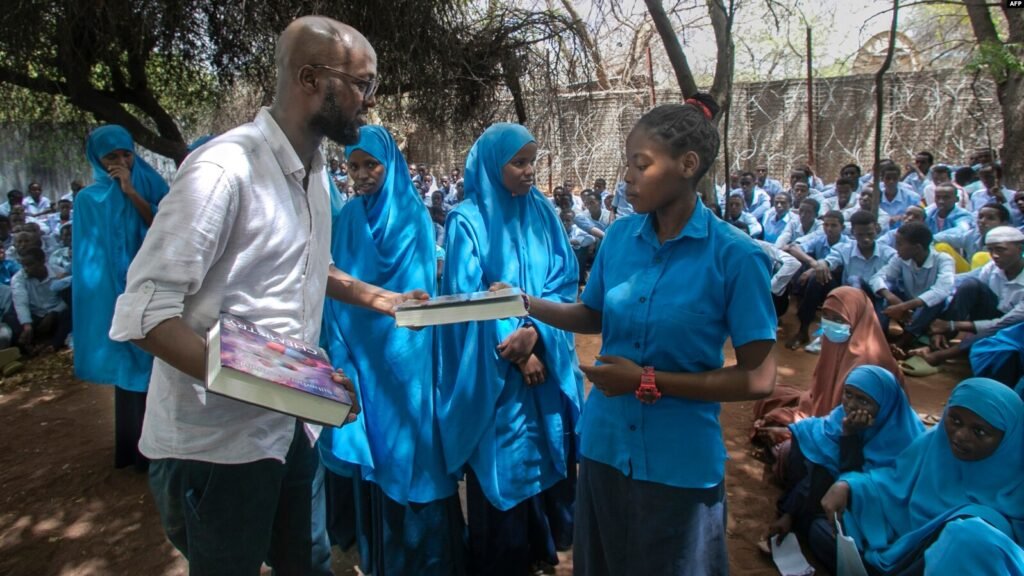 This handout picture taken on Nov. 8, 2023, shows Abdullahi Mire, winner of the U.N. refugee agency's prestigious Nansen Award, posing for a picture in one of the libraries he established in Kenya's Dadaab refugee camp. (AFP Photo/UNHCR)